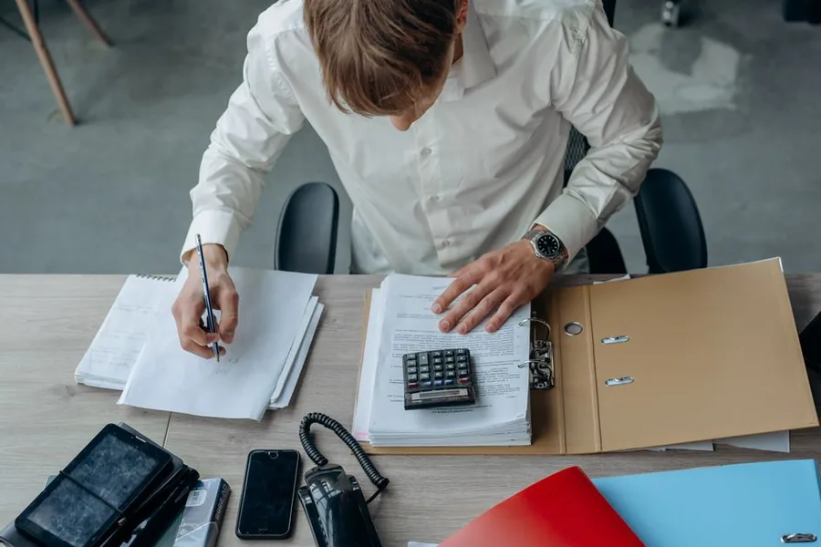 A contractor reviewing invoices and running the figures to check whether the VAT reverse charge applies to the job A contractor reviewing invoices and running the figures to check whether the VAT reverse charge applies to the job