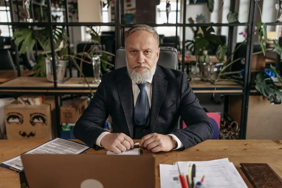 A company director reviewing loan account paperwork and figures at their office desk A company director reviewing loan account paperwork and figures at their office desk