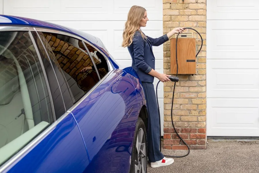 A UK professional plugging her electric company car into a home wallbox charger, a popular salary sacrifice benefit A UK professional plugging her electric company car into a home wallbox charger, a popular salary sacrifice benefit
