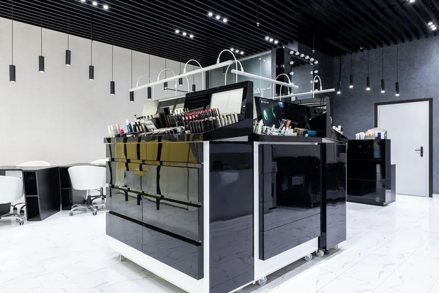 A salon assistant selling a retail haircare product to a client at the till A salon assistant selling a retail haircare product to a client at the till