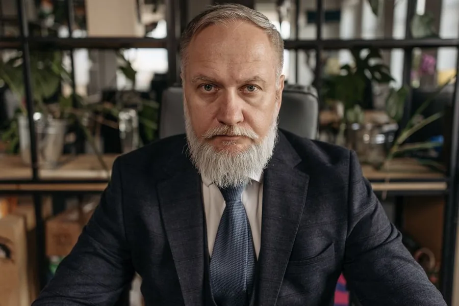 A company director in a tailored suit at his office desk, reviewing how to structure pay and dividends around National Insurance A company director in a tailored suit at his office desk, reviewing how to structure pay and dividends around National Insurance