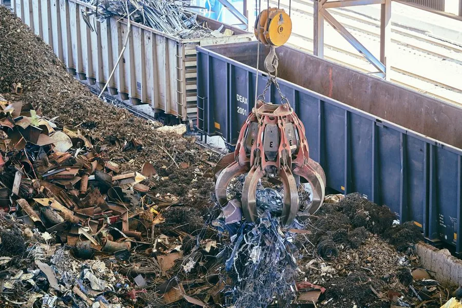 A crane grab loading mixed scrap metal into a rail wagon at a recycling yard, the trade covered by the VAT reverse charge scheme A crane grab loading mixed scrap metal into a rail wagon at a recycling yard, the trade covered by the VAT reverse charge scheme