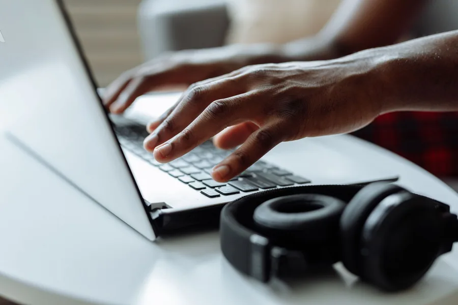 Close-up of a self-employed freelancer typing on a laptop while keeping their bookkeeping up to date at a desk Close-up of a self-employed freelancer typing on a laptop while keeping their bookkeeping up to date at a desk
