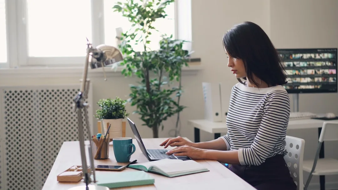 Self-employed sole trader at a kitchen table working out National Insurance on a laptop
