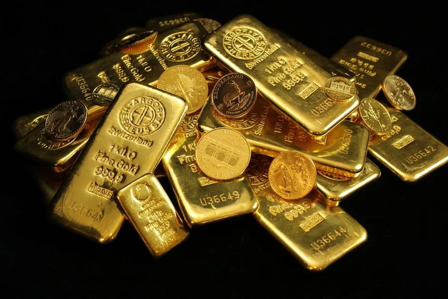 Gold bullion bars and coins piled on a dark surface, the kind of holding HMRC weighs as trading or investment Gold bullion bars and coins piled on a dark surface, the kind of holding HMRC weighs as trading or investment