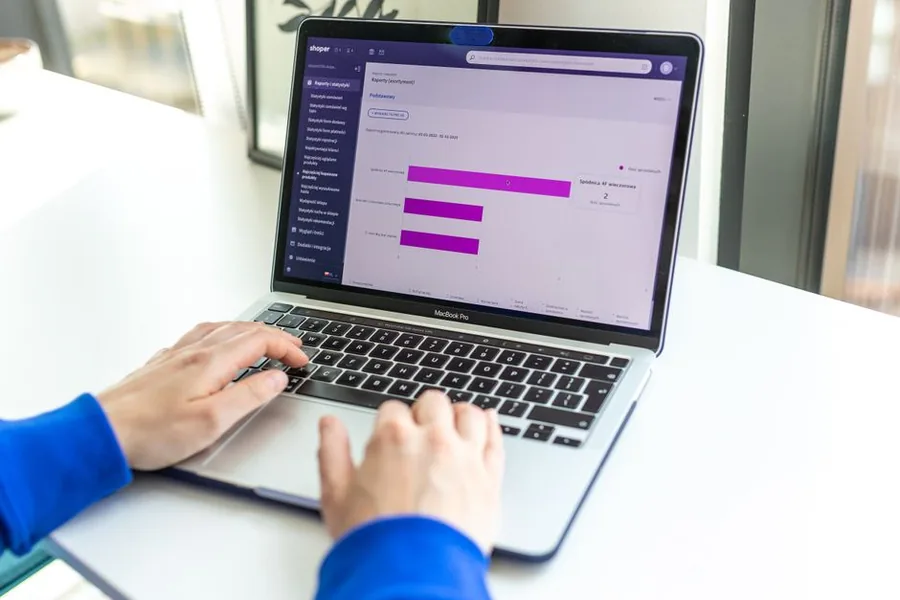 A UK online shop owner reviewing ecommerce sales reports on a laptop to reconcile takings for VAT and cost of goods A UK online shop owner reviewing ecommerce sales reports on a laptop to reconcile takings for VAT and cost of goods