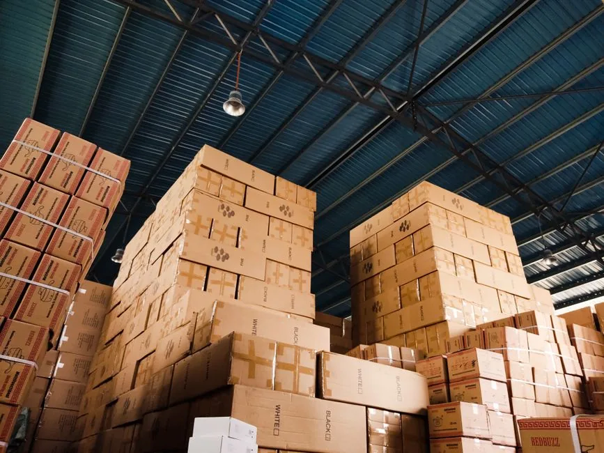 Boxed wholesale stock stacked high in a distribution warehouse ready for B2B ecommerce dispatch Boxed wholesale stock stacked high in a distribution warehouse ready for B2B ecommerce dispatch