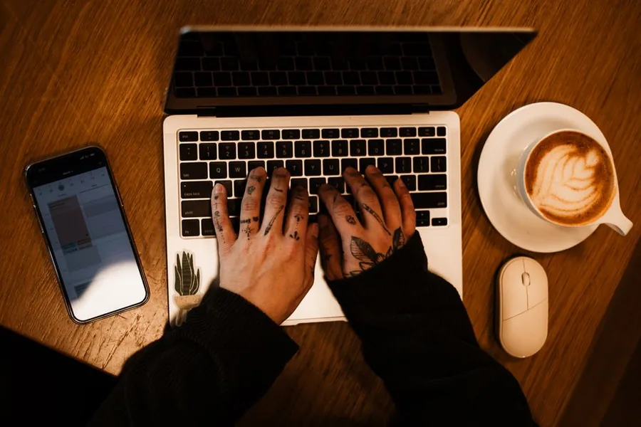 A sole trader working late on a laptop at home, building a side hustle alongside the day job