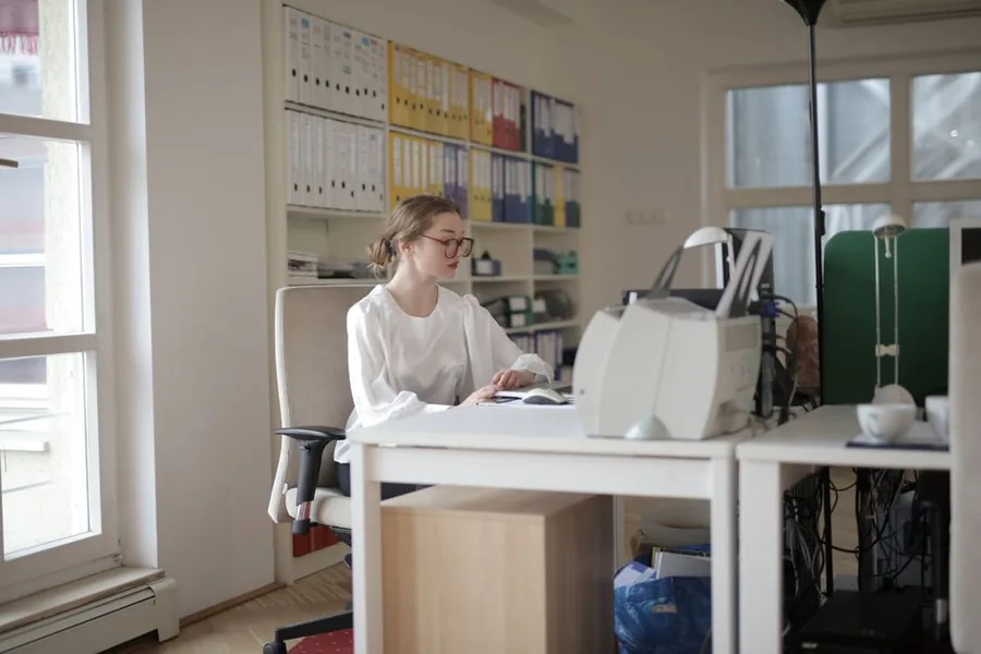 A small business owner reviewing accounts at a tidy office desk while working through year-end tax admin A small business owner reviewing accounts at a tidy office desk while working through year-end tax admin