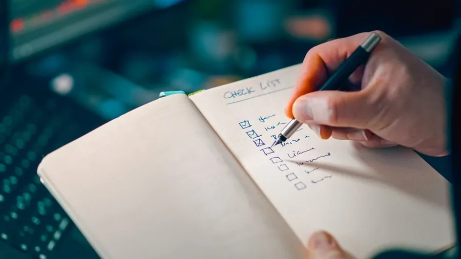 A new employee working through a checklist by hand, much like completing the HMRC Starter Checklist statements A new employee working through a checklist by hand, much like completing the HMRC Starter Checklist statements