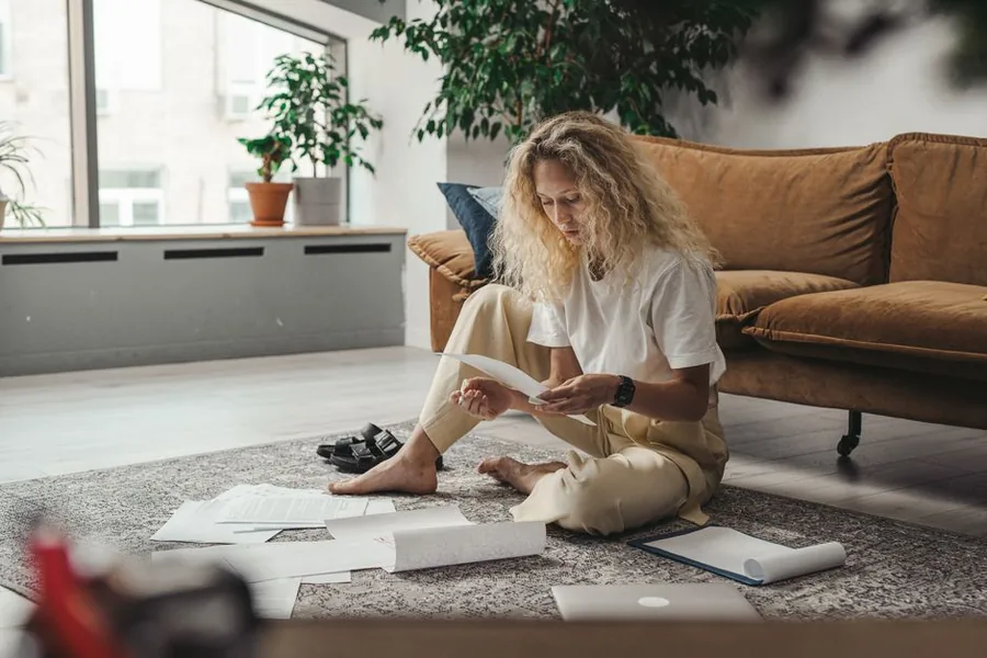 A self-employed worker at home sorting through paperwork and receipts to work out her income tax bill A self-employed worker at home sorting through paperwork and receipts to work out her income tax bill