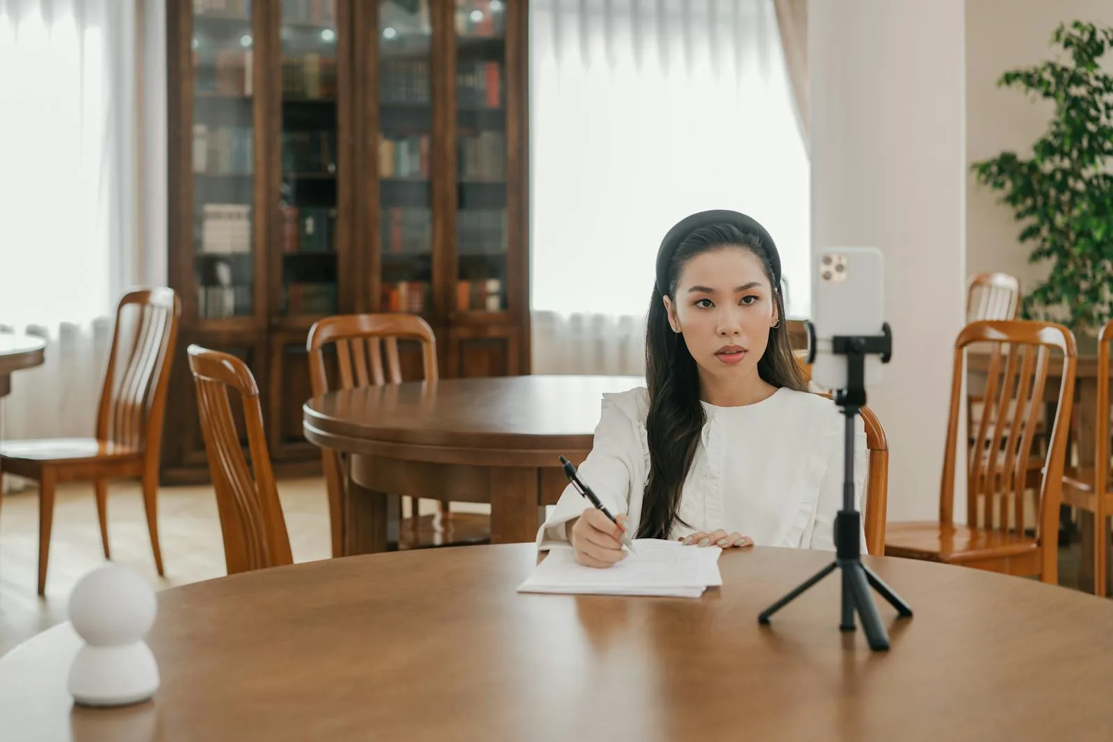 A UK TikTok creator at a desk reviewing a USD payout statement on a laptop next to a currency conversion app on a phone