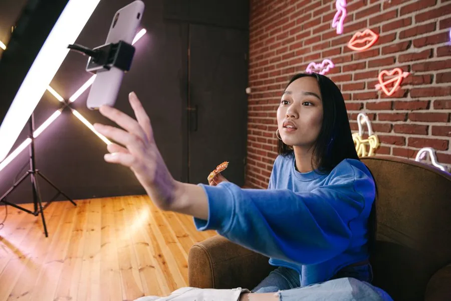 A TikTok creator filming a product review at home on a ring-light phone setup A TikTok creator filming a product review at home on a ring-light phone setup