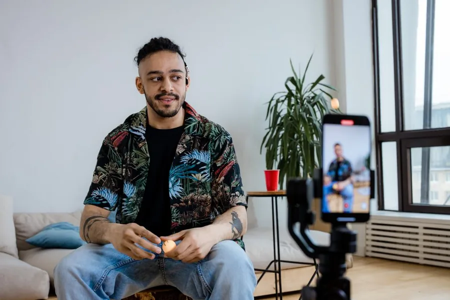 A UK content creator recording a video on a smartphone gimbal at home, the sort of self-employed earner paying Class 4 NI A UK content creator recording a video on a smartphone gimbal at home, the sort of self-employed earner paying Class 4 NI