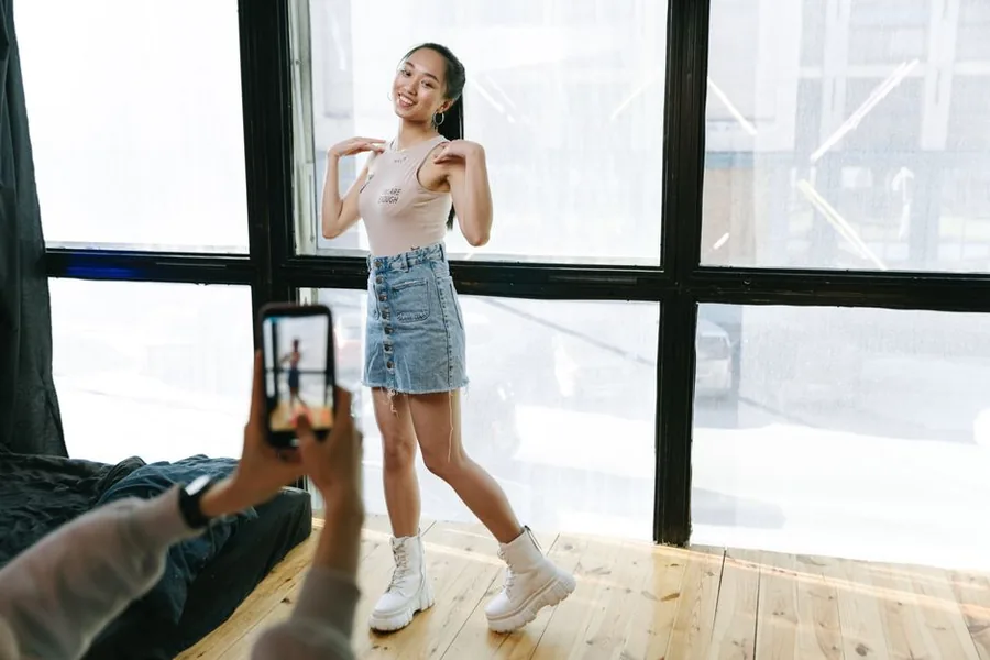 A TikTok creator recording video content on a smartphone gimbal in a home studio setup A TikTok creator recording video content on a smartphone gimbal in a home studio setup