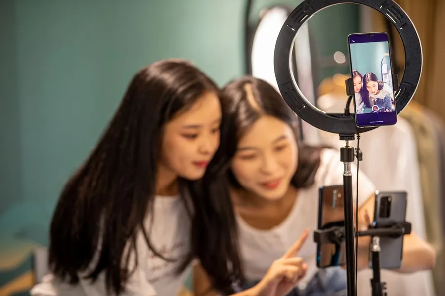 Two creators livestreaming a product to camera through a ring light, the way many TikTok Shop sellers and affiliates film