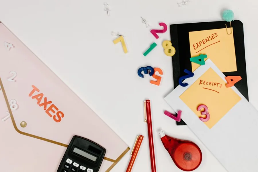 Labelled expenses and receipts folders beside a calculator, a simple setup for keeping small business spending organised