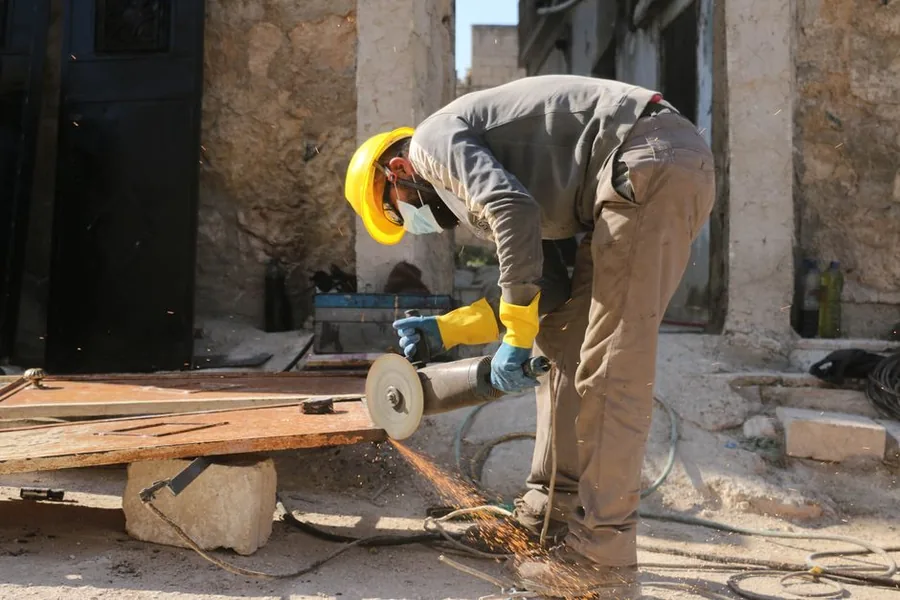 A tradesperson in a hard hat fitting an electrical wall socket, the kind of self-employed contractor weighing up VAT registration A tradesperson in a hard hat fitting an electrical wall socket, the kind of self-employed contractor weighing up VAT registration