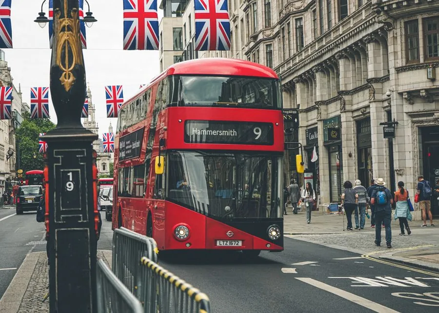 Tourists on a central London street beside a red double-decker bus, the kind of trade covered by the Tour Operators Margin Scheme