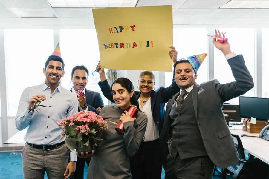 Colleagues at a small UK firm celebrating a birthday with flowers, party hats and a card, a classic trivial benefit Colleagues at a small UK firm celebrating a birthday with flowers, party hats and a card, a classic trivial benefit