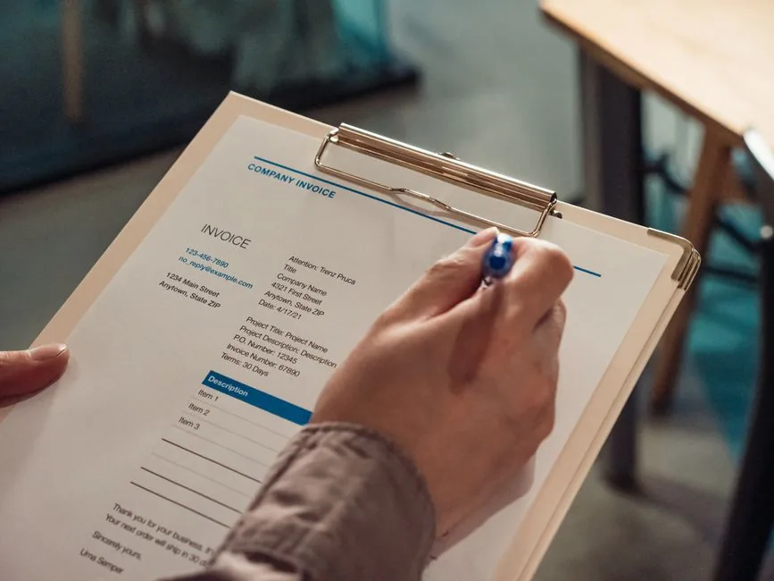 A company invoice being completed by hand, the manual paperwork Peppol e-invoicing is set to replace for UK businesses