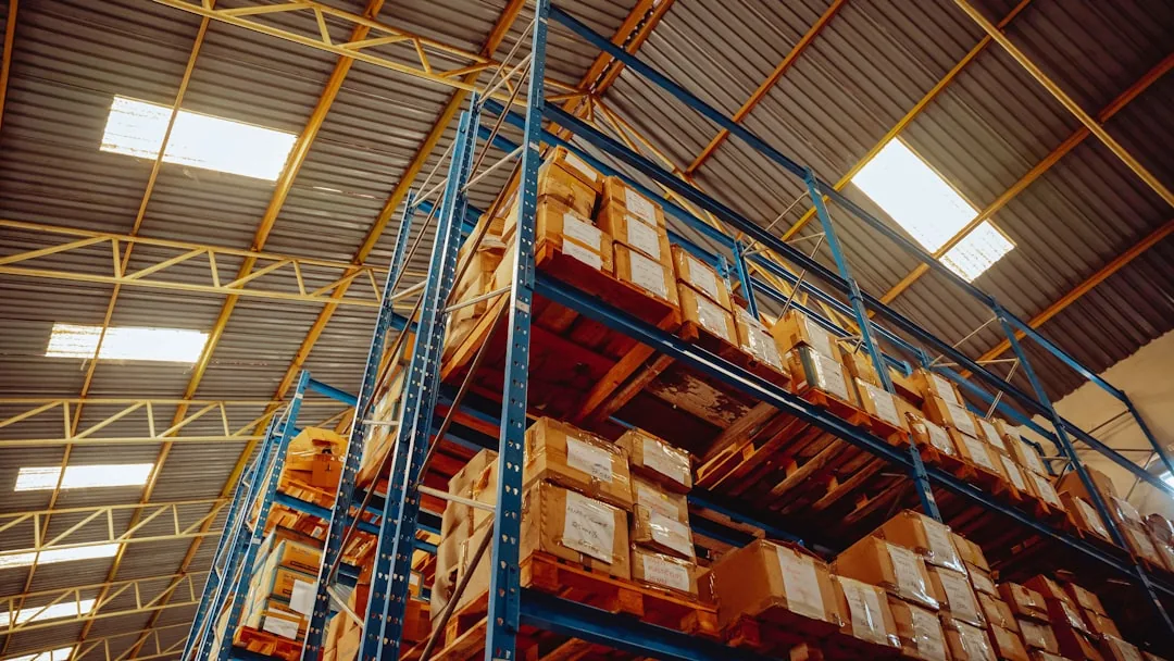 A UK ecommerce seller packing parcels and checking EU VAT, OSS and IOSS rules on a laptop