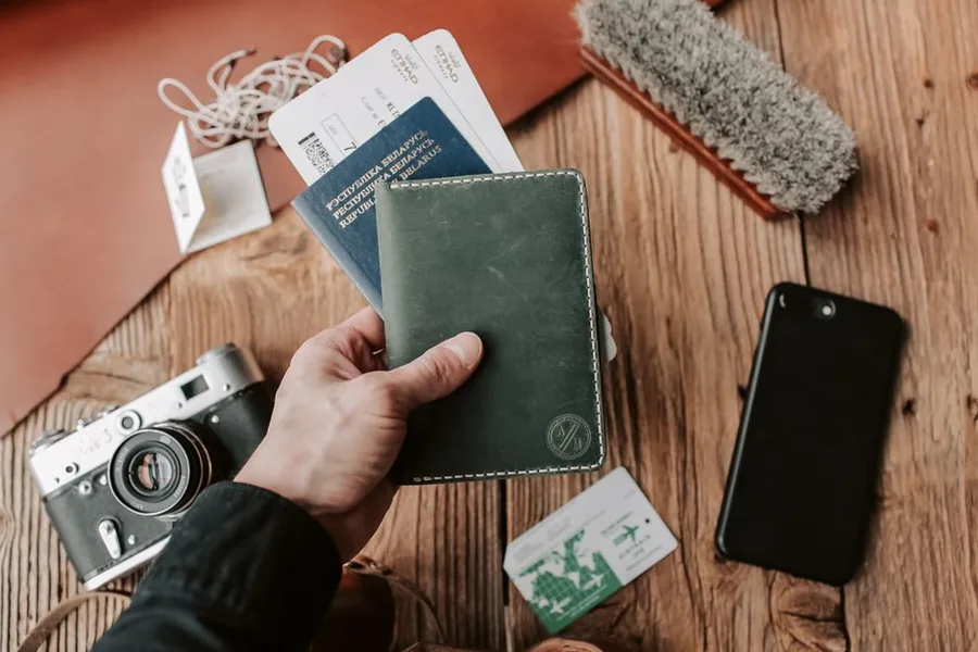 A traveller holding a passport and boarding passes before a trip, a reminder that days spent abroad shape UK tax residence A traveller holding a passport and boarding passes before a trip, a reminder that days spent abroad shape UK tax residence