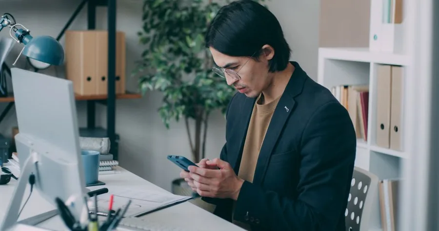 A small business owner reviewing invoices and payment dates at a desk while working out VAT on a cash accounting basis