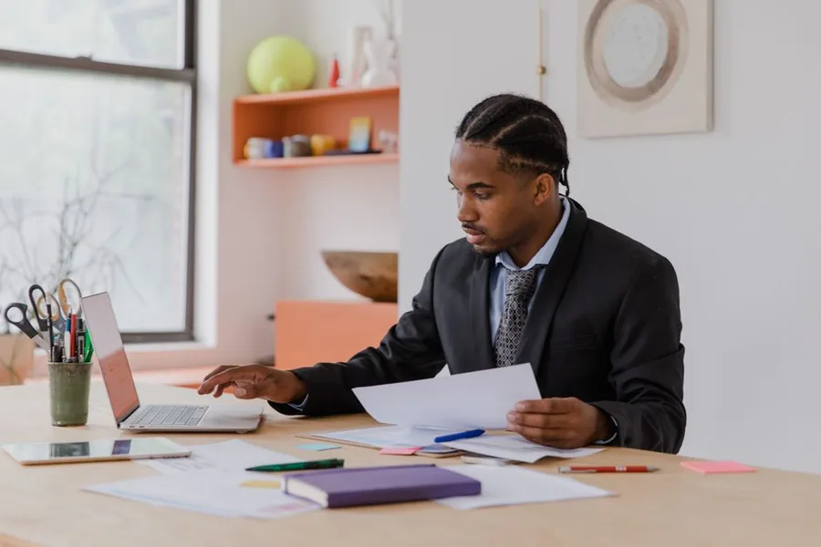 A small business owner reviewing turnover records at a laptop to check whether to cancel their VAT registration A small business owner reviewing turnover records at a laptop to check whether to cancel their VAT registration