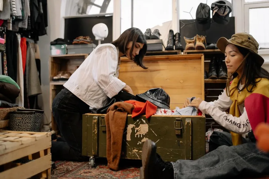 Shoppers sorting through second-hand clothing and vintage finds in a UK resale shop Shoppers sorting through second-hand clothing and vintage finds in a UK resale shop