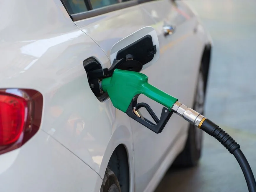 A fuel nozzle refuelling a white company car on a forecourt, the everyday cost behind reclaiming VAT on business fuel A fuel nozzle refuelling a white company car on a forecourt, the everyday cost behind reclaiming VAT on business fuel