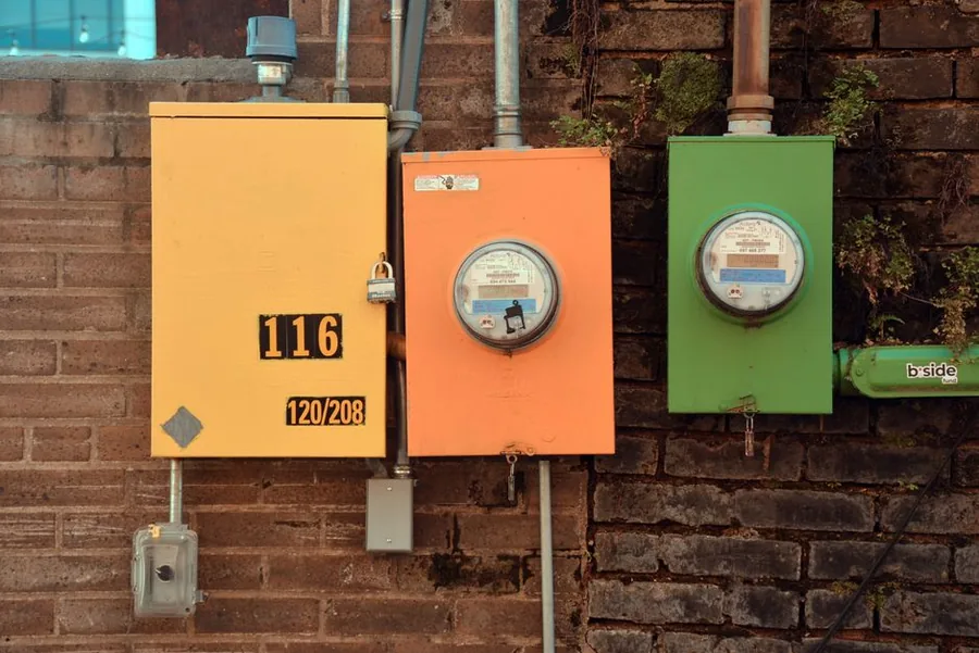 A bank of domestic gas meters mounted on an external wall, recording household energy use for billing A bank of domestic gas meters mounted on an external wall, recording household energy use for billing