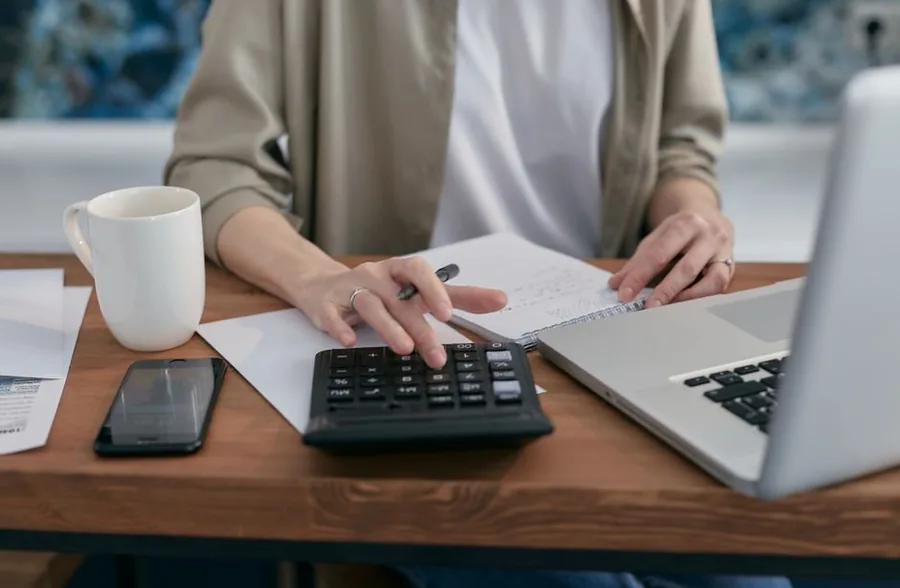 A self-employed worker totting up turnover on a calculator to check whether takings have crossed the VAT registration threshold A self-employed worker totting up turnover on a calculator to check whether takings have crossed the VAT registration threshold