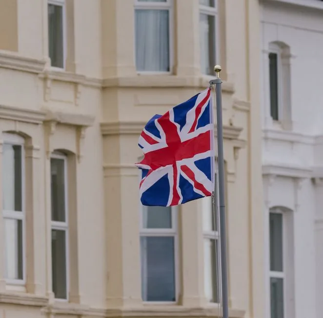 A Union Jack flying outside a British townhouse, evoking the UK government system behind National Insurance numbers A Union Jack flying outside a British townhouse, evoking the UK government system behind National Insurance numbers