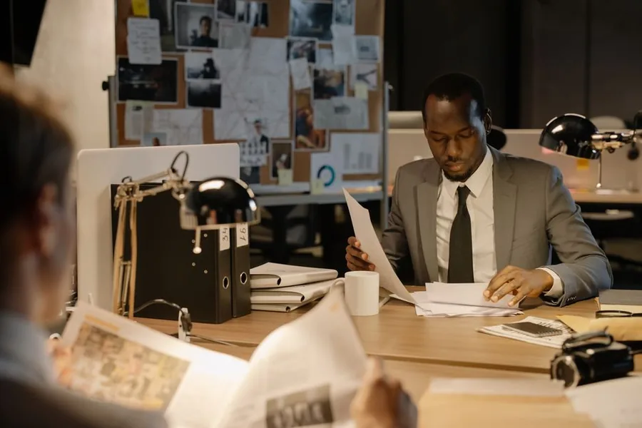 An investigator reviewing case paperwork and files, reflecting the scrutiny behind an HMRC tax enquiry An investigator reviewing case paperwork and files, reflecting the scrutiny behind an HMRC tax enquiry