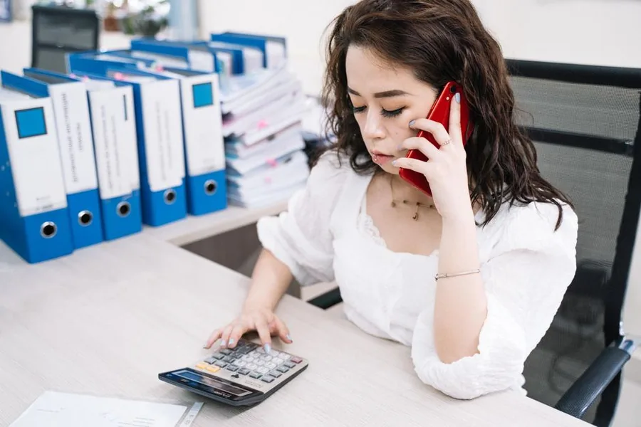 A small business owner checking turnover on a calculator to see whether takings have crossed the VAT registration threshold A small business owner checking turnover on a calculator to see whether takings have crossed the VAT registration threshold