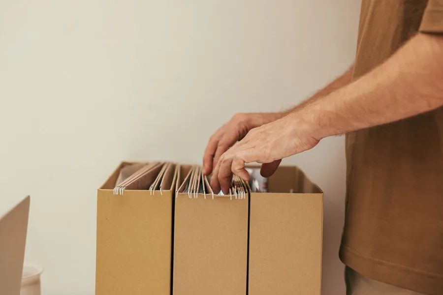 Sorting paperwork from a box file to gather records ready to submit a self assessment tax return early Sorting paperwork from a box file to gather records ready to submit a self assessment tax return early