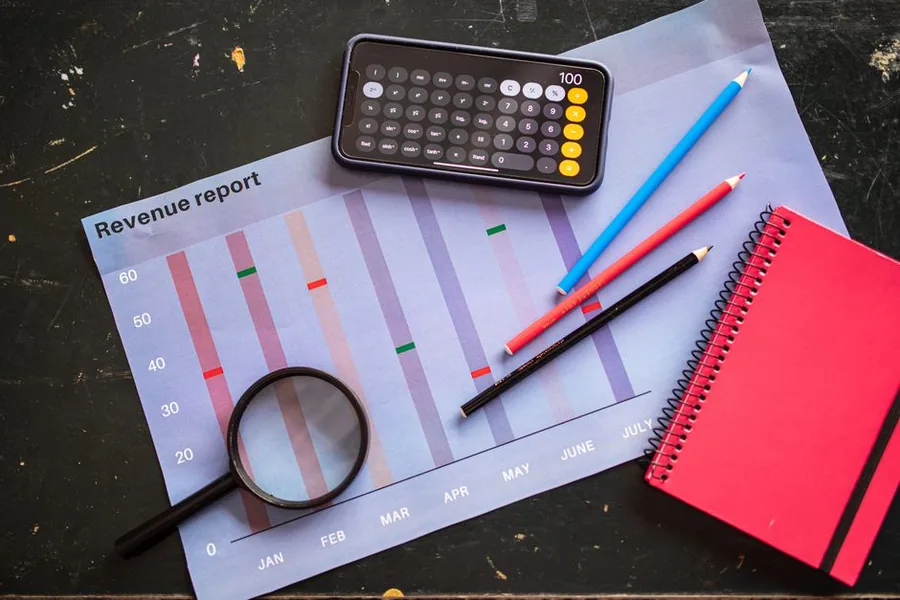 A monthly revenue report chart reviewed with a calculator and notebook, tracking membership income recognised over time A monthly revenue report chart reviewed with a calculator and notebook, tracking membership income recognised over time