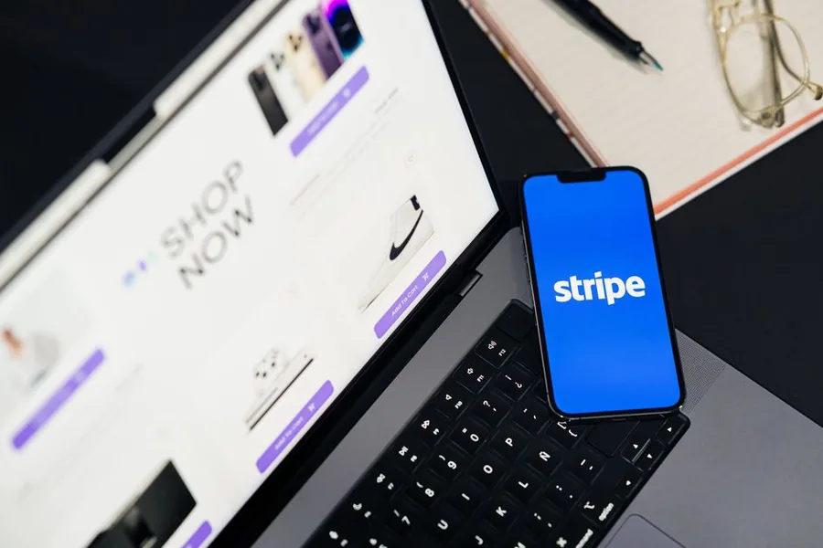 The Stripe app open on a phone beside an online store checkout screen, the payment stack UK WooCommerce sellers reconcile The Stripe app open on a phone beside an online store checkout screen, the payment stack UK WooCommerce sellers reconcile