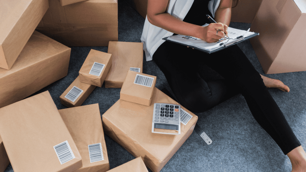 Hands packaging items, hinting at e-commerce accounting and tax considerations.