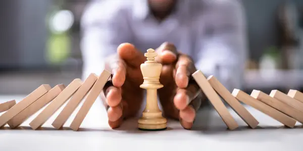 Hands arranging chess pieces, representing strategic planning in accounting.