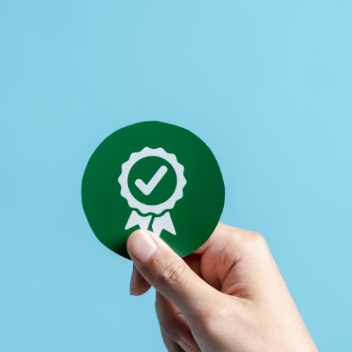 A hand holding a green checkmark, symbolizing compliance in accounting practices.
