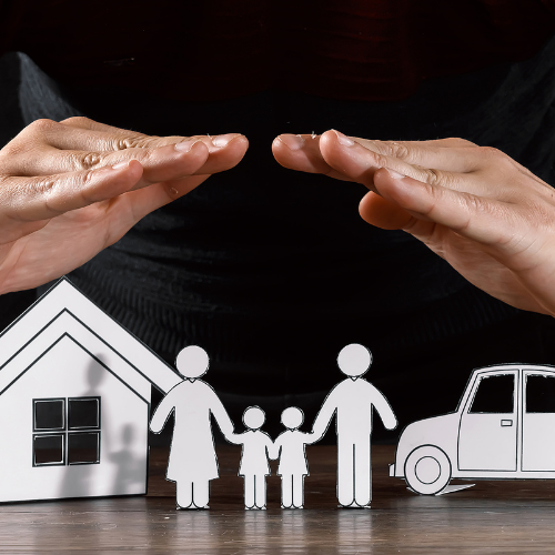 Hands protecting a family, house, and car figurines, symbolizing financial planning and tax protection for families.