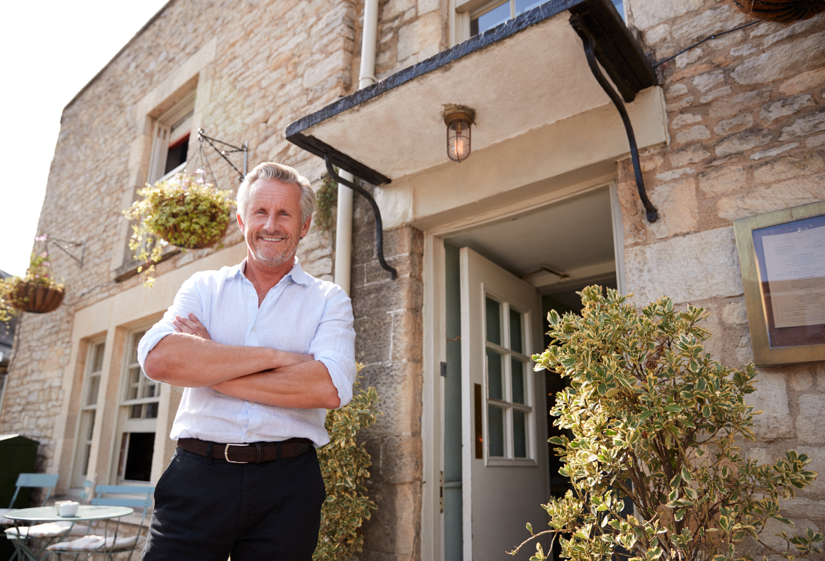 Businessman standing confidently in front of a house for real estate accounting services