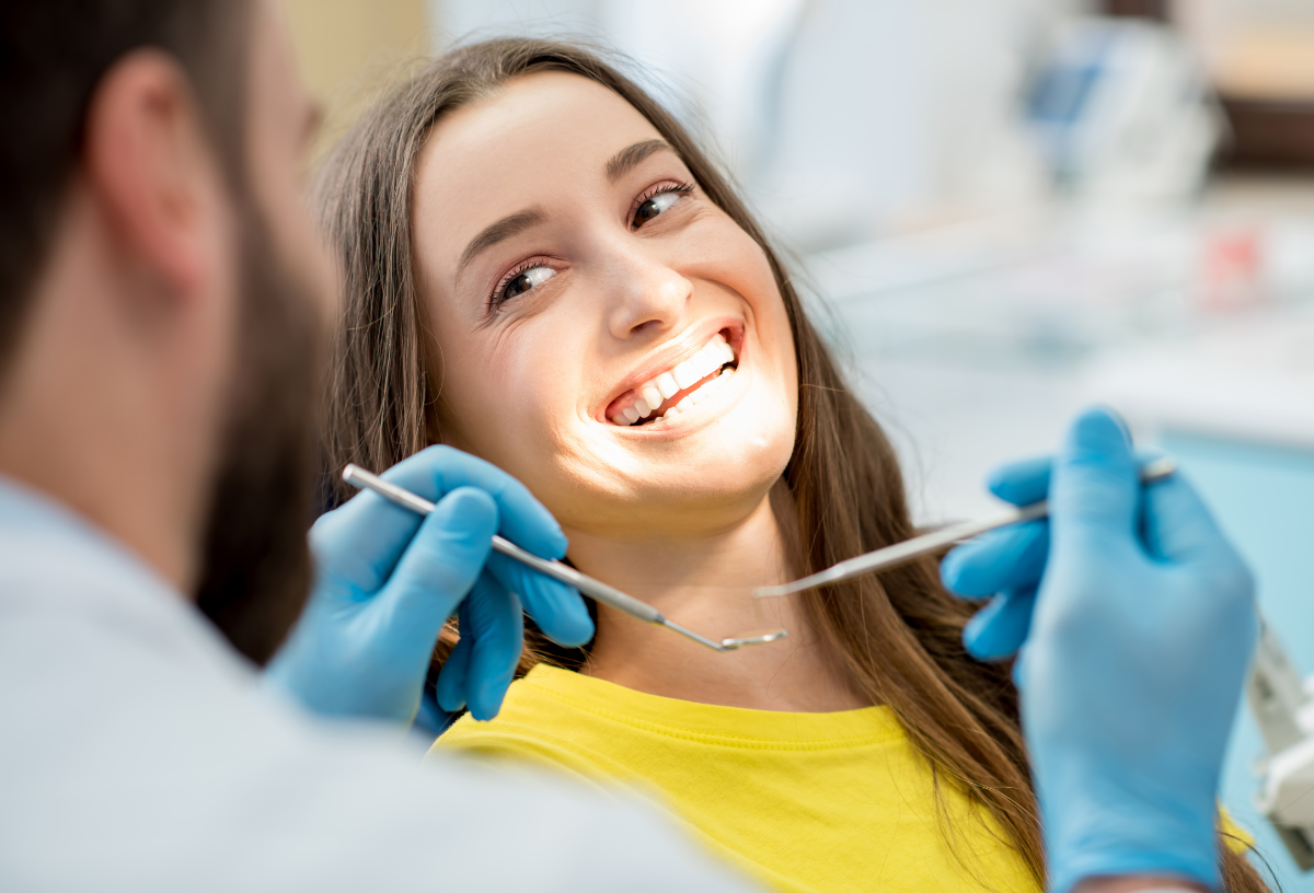 A woman in a dental chair, smiling while undergoing a dental procedure.