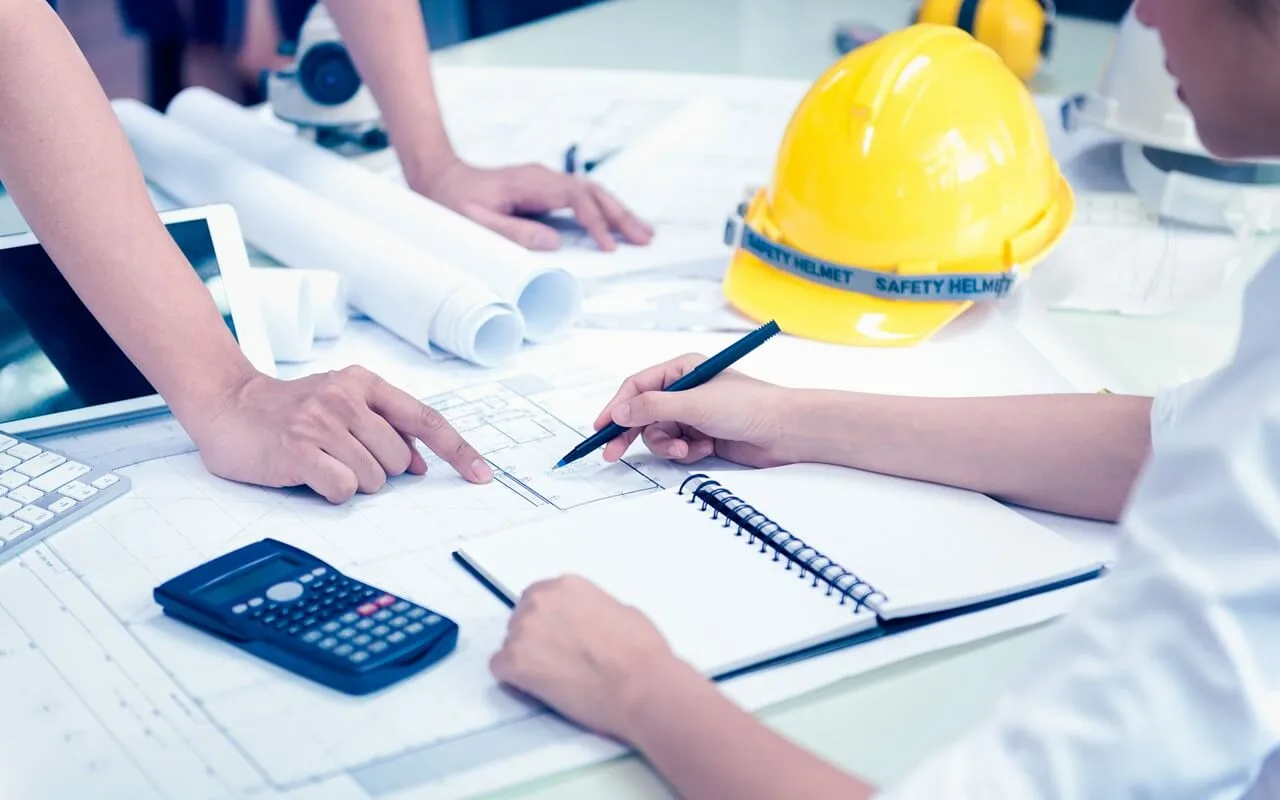 Construction worker reviewing blueprints for project accounting